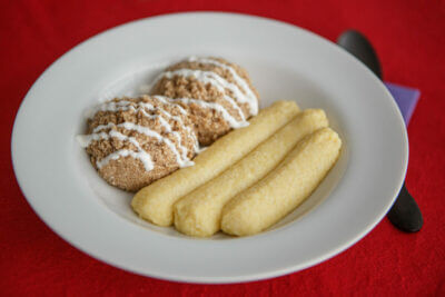 Dysphagia-friendly jerk chicken with breadsticks in white bowl